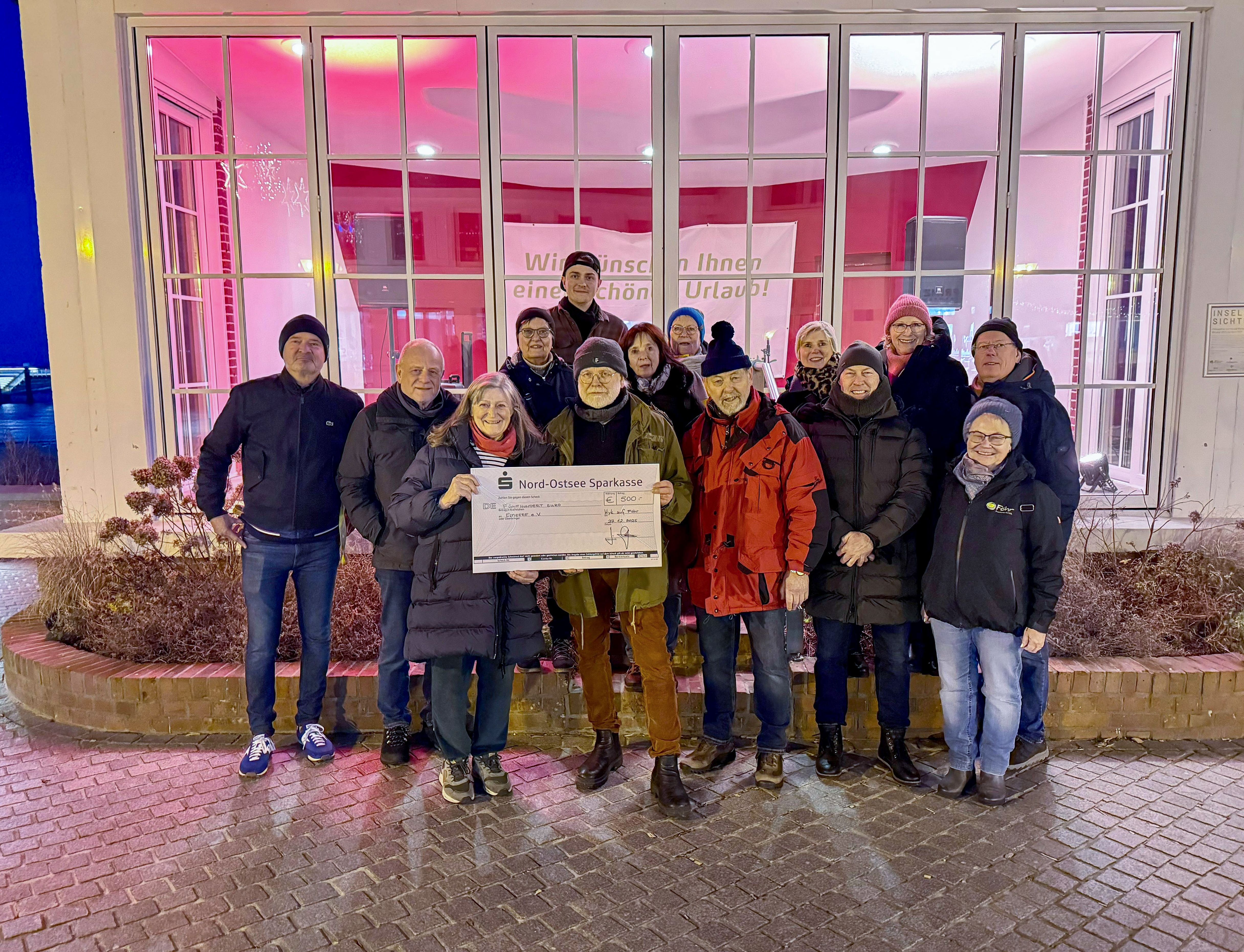Übergabe Spendenscheck durch eine Gruppe des Clubs der Föhr-Freunde vor dem Musikpavillon in Wyk auf Föhr