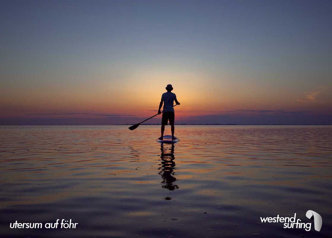 Stand-Up-Paddler paddelt vor Föhr in den Sonnenuntergang