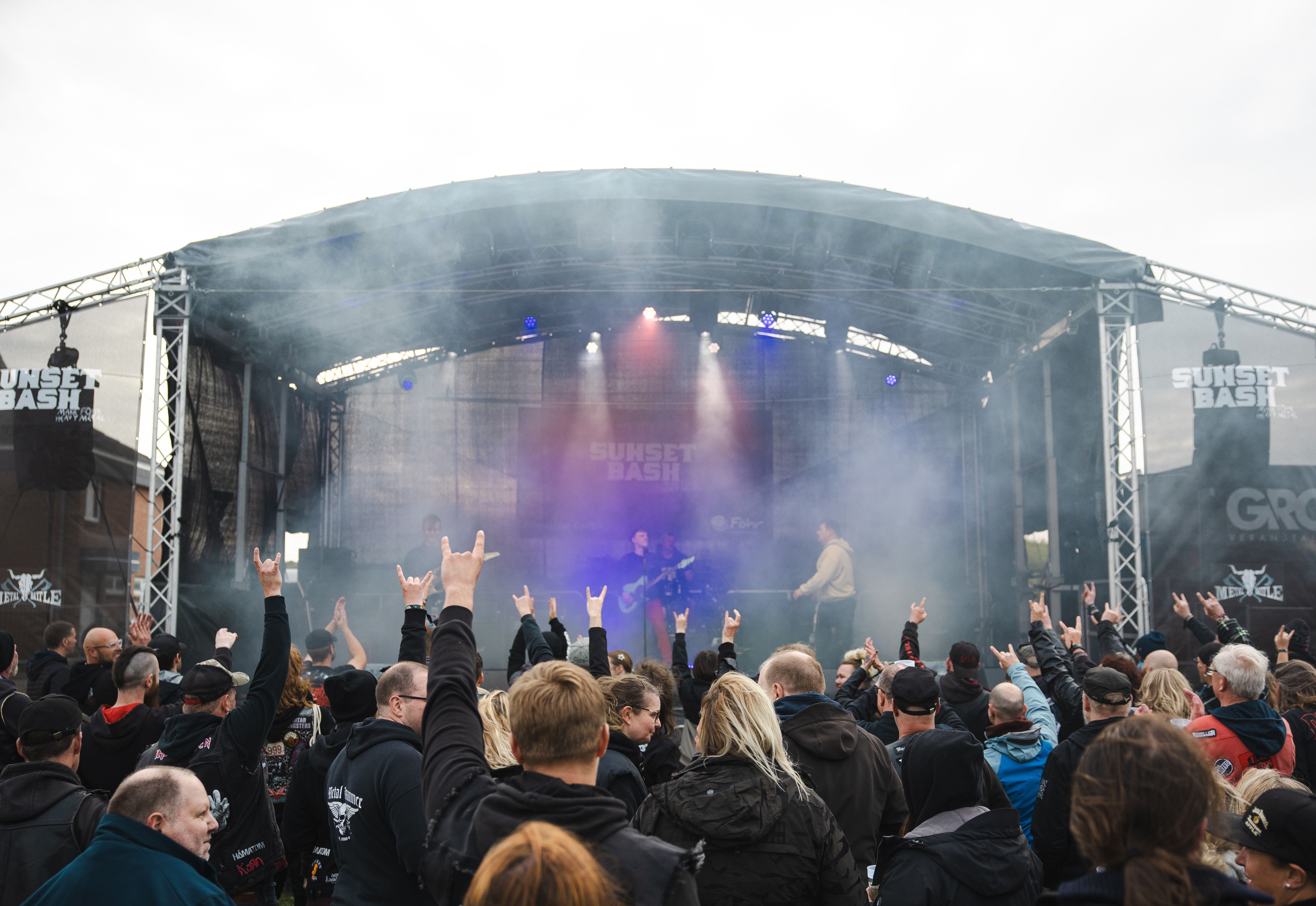 Metal-Fans von hinten mit Blick auf eine Musikbühne