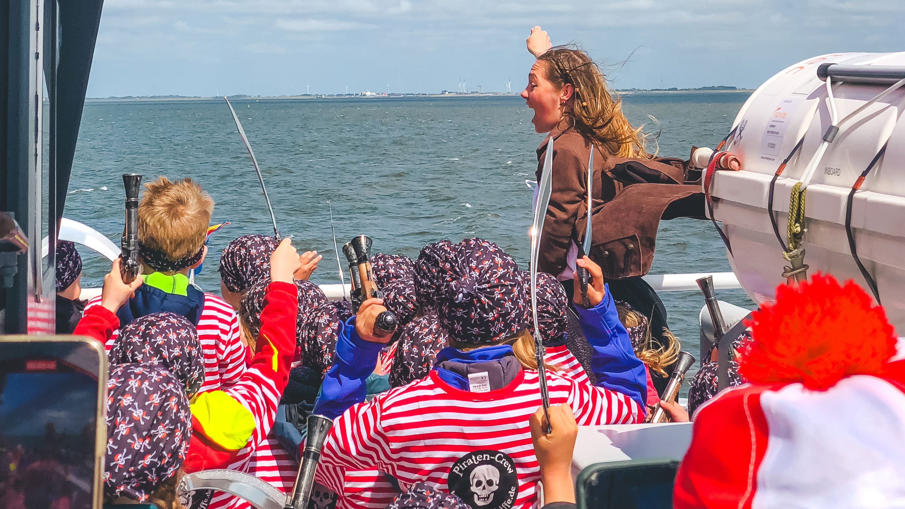 Eine Frau und Kinder in Piratenkostümen auf einem Schiff