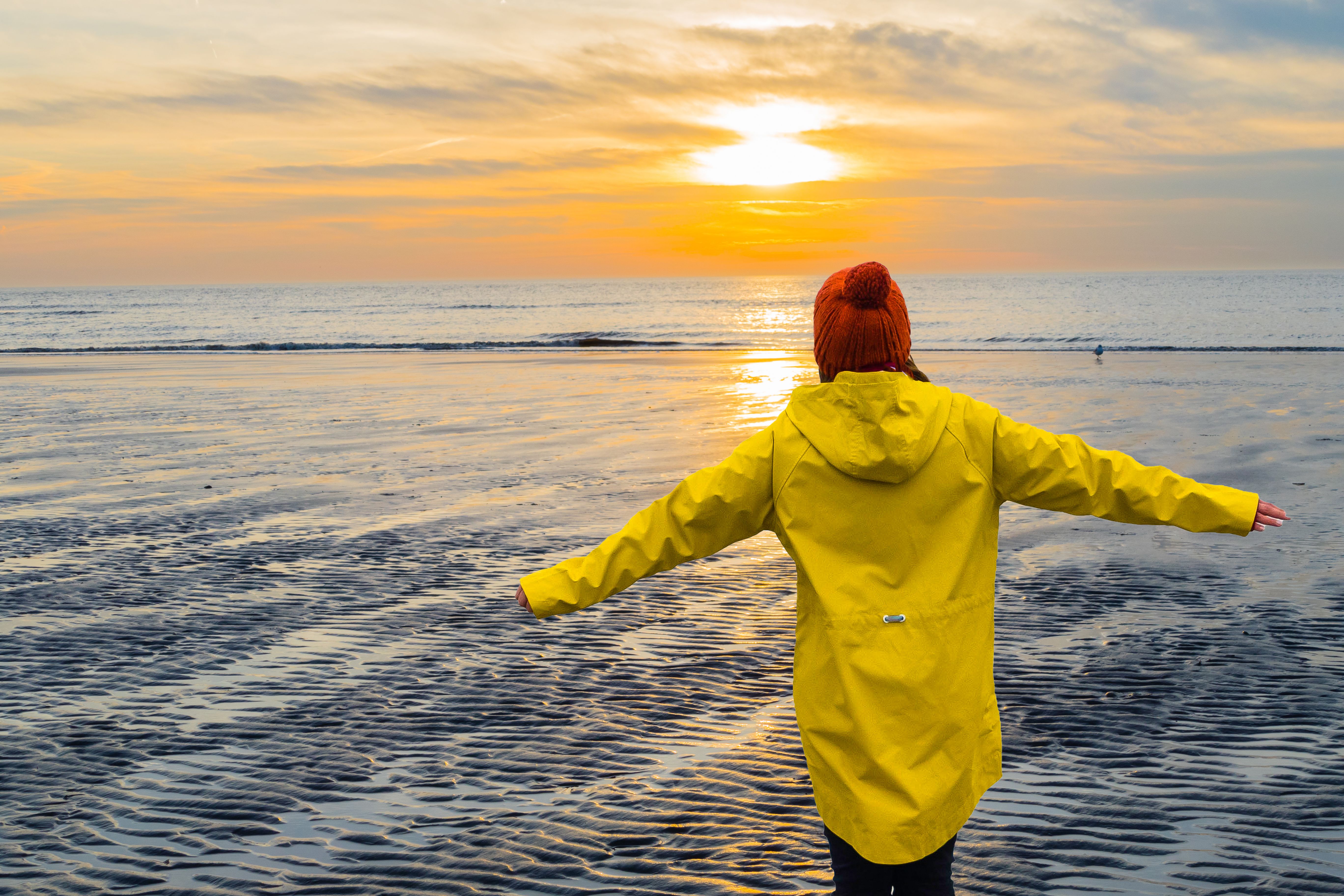 Frau genießt Sonnenuntergang am Strand