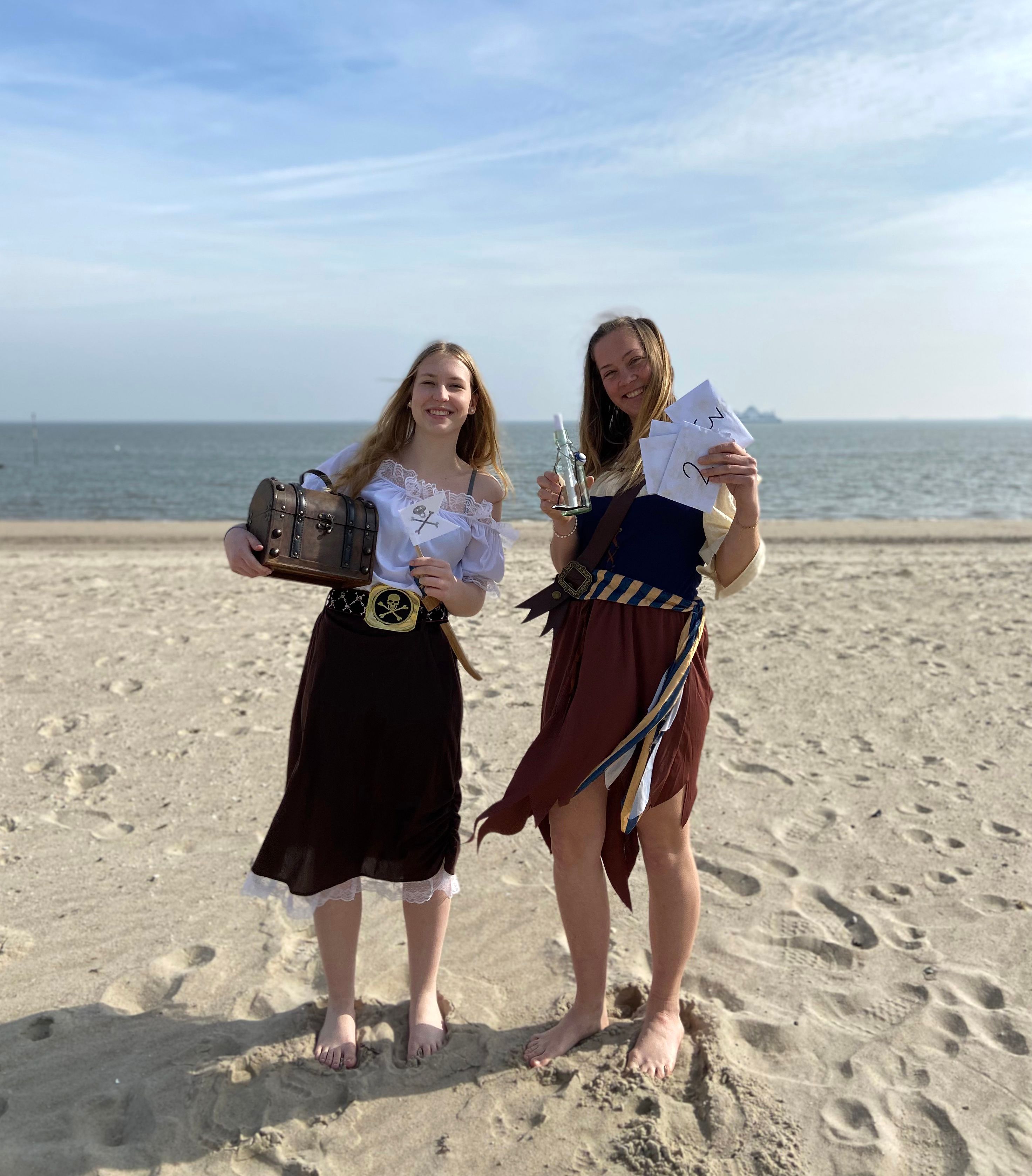 Zwei junge Frauen in Piratenkostüm am Strand
