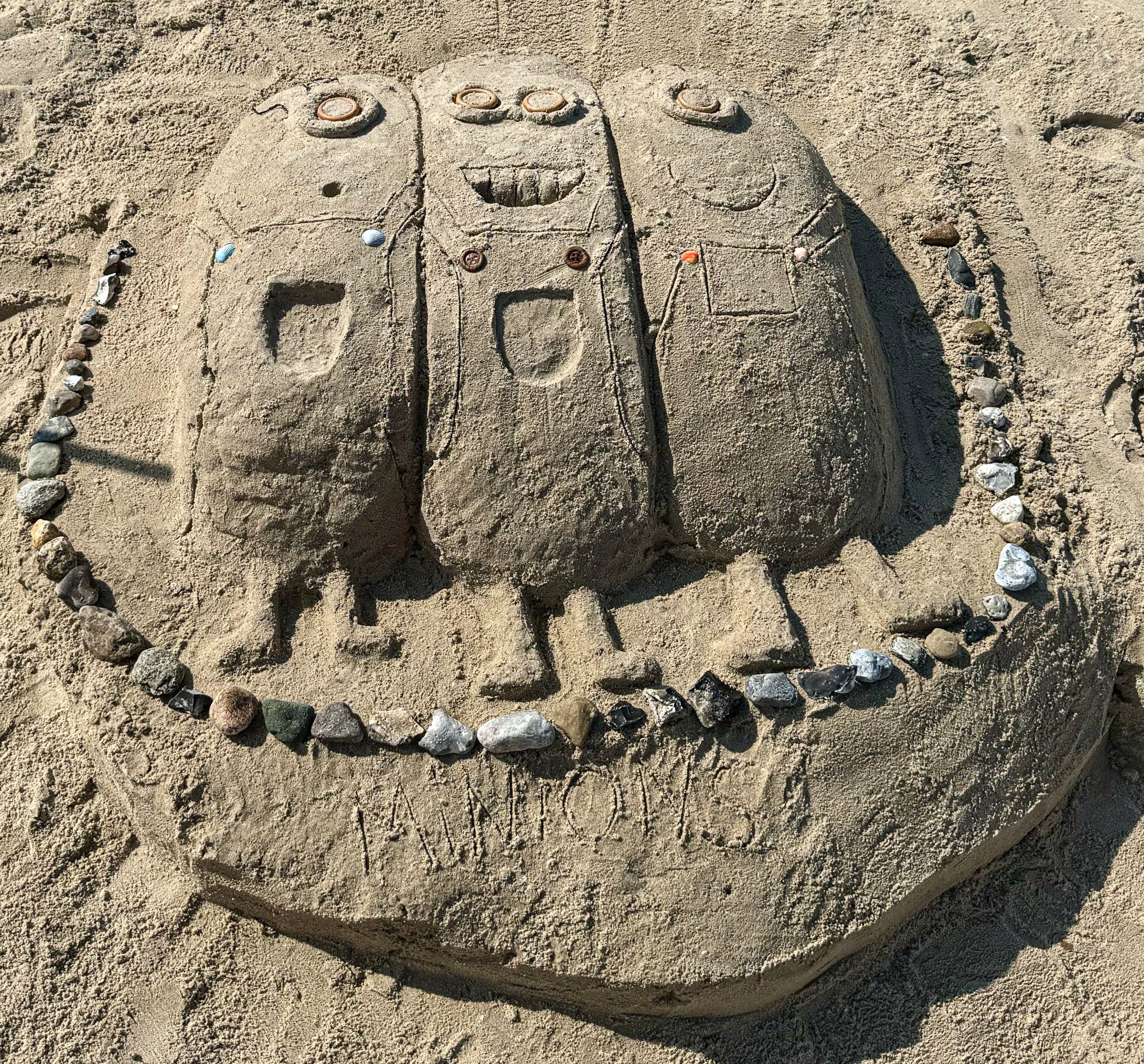 Drei Minions-Figuren aus Sand