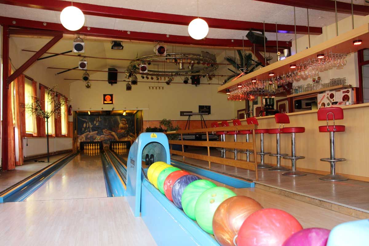 Bowlingkugeln und Blick auf Bar im Bowlingcenter Bi Jaine