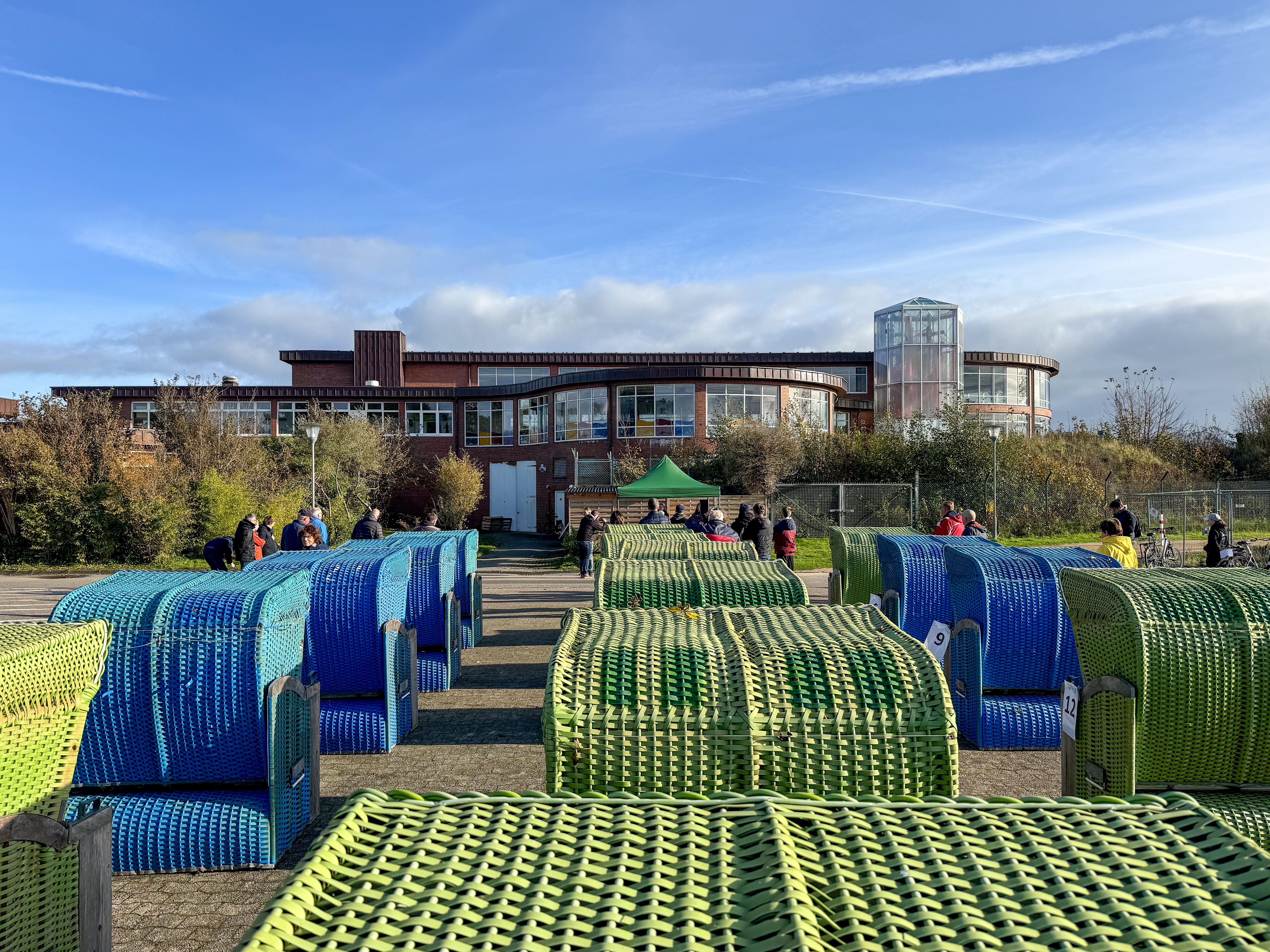 Rückansicht von einer Reihe von Strandkörben auf einem Parkplatz vor einer Versteigerung
