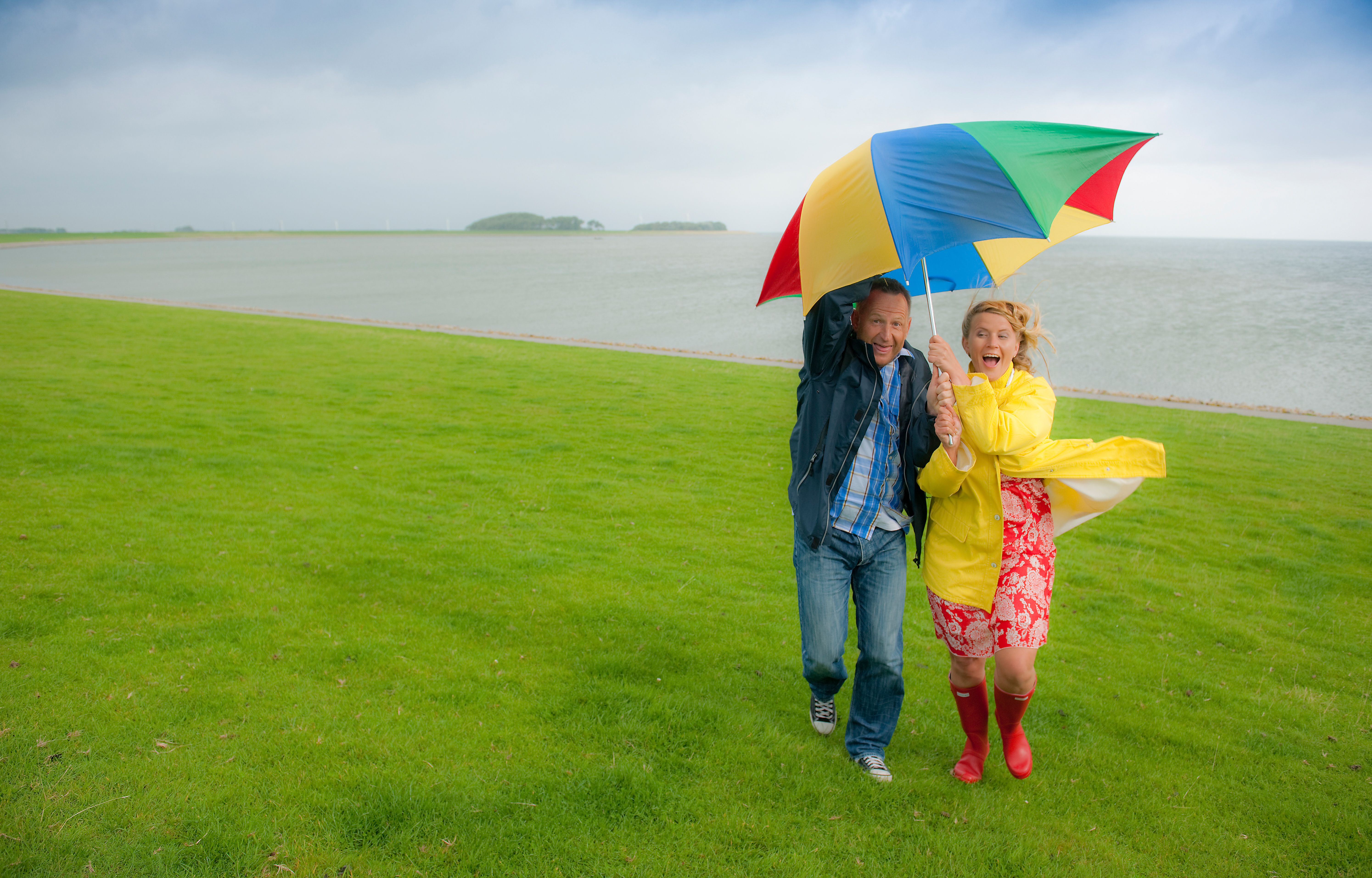 Pärchen am Deich unterm Regenschirm