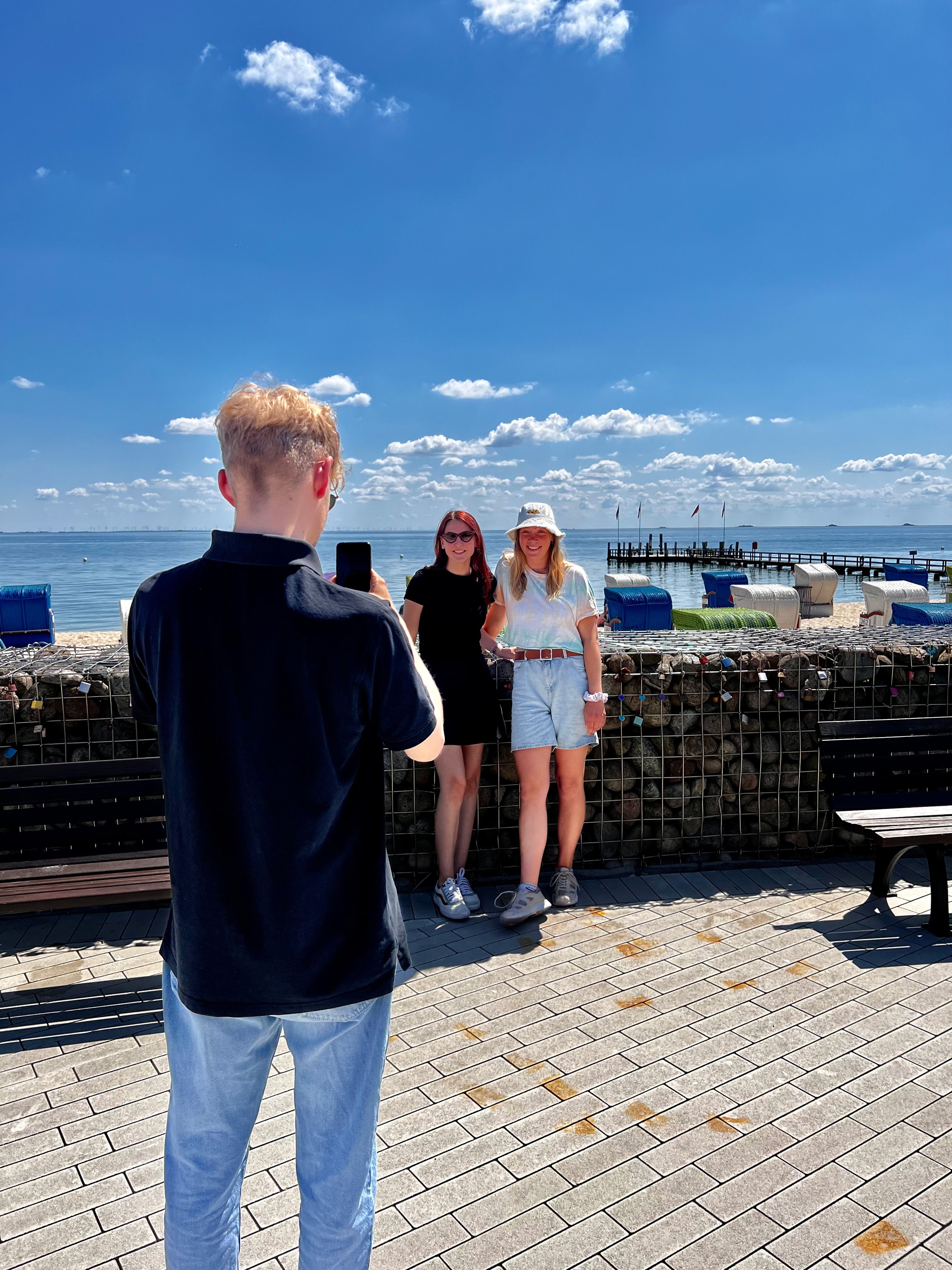 Foto-Helfer macht Fotos von zwei Personen auf der Wyker Strandpromenade.