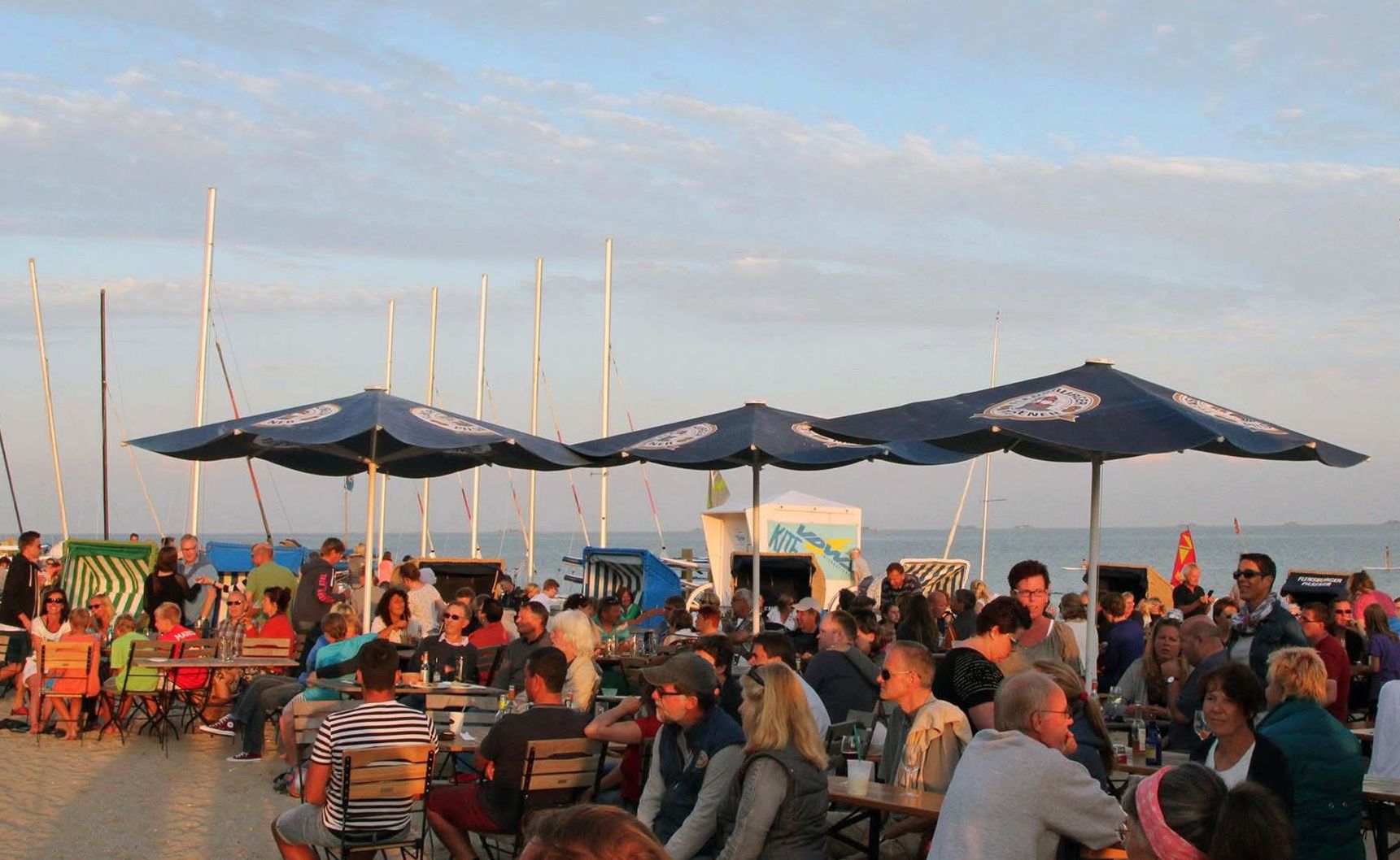 Sitzende Personen bei einer Beachparty am Strand