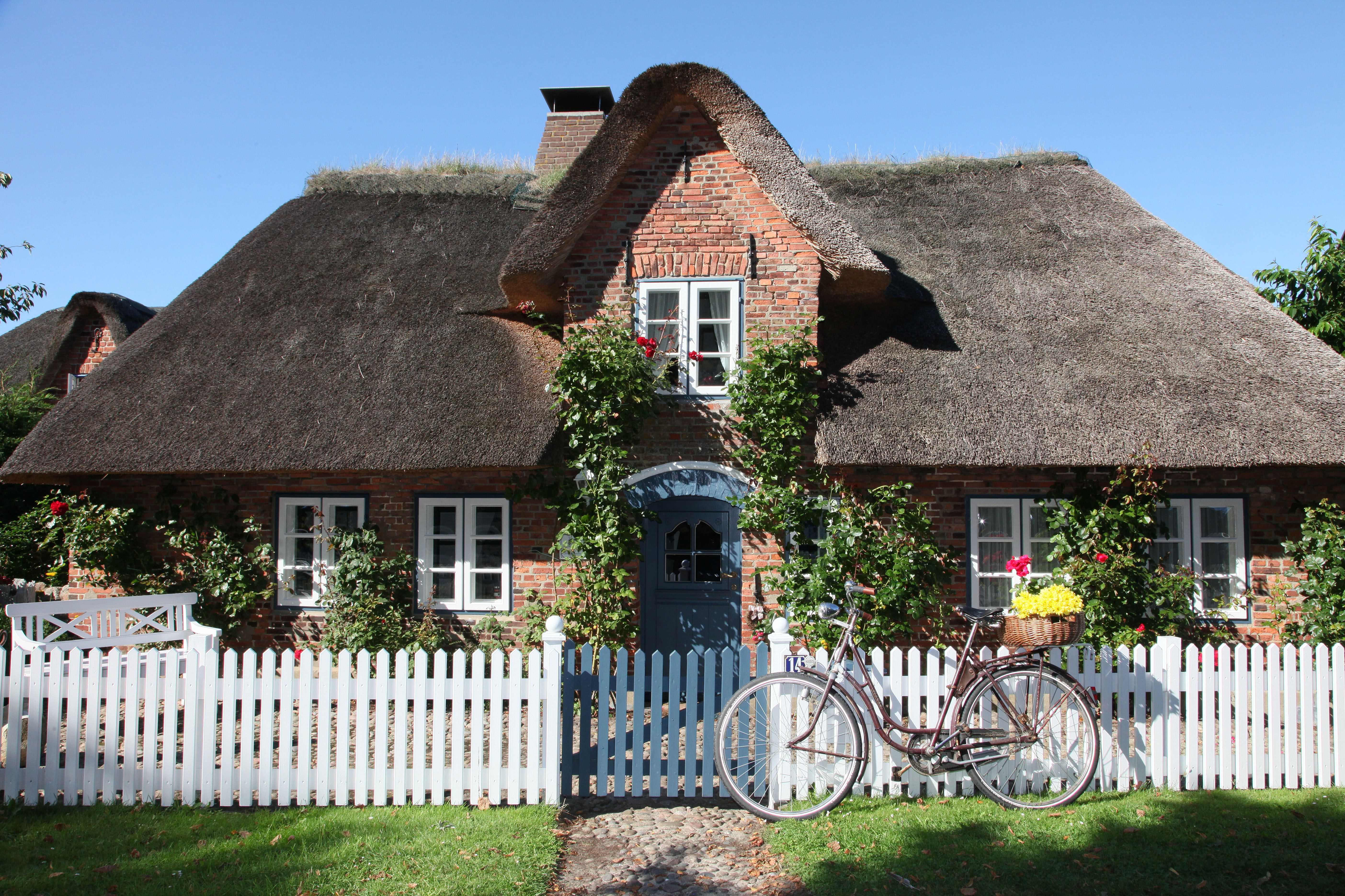 Friesenhaus mit Fahrrad am Zaun